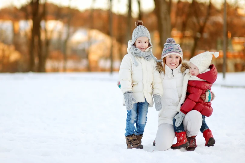 Młoda matka i dwoje dzieci na tle zimowego krajobrazu