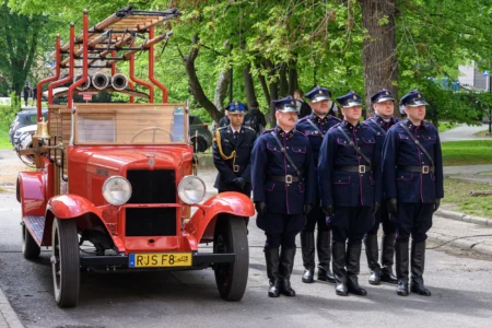 Strażacy podczas wydarzenia inaugurującego obchody jubileuszu 75-lecia powstania rzeszowskiej Komendy Wojewódzkiej PSP. Z zabytkowym wozem strażackim.