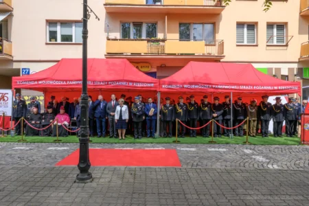 Uczestnicy uroczystości stojący na placu przy ul. Mickiewicza 10 w Rzeszowie.