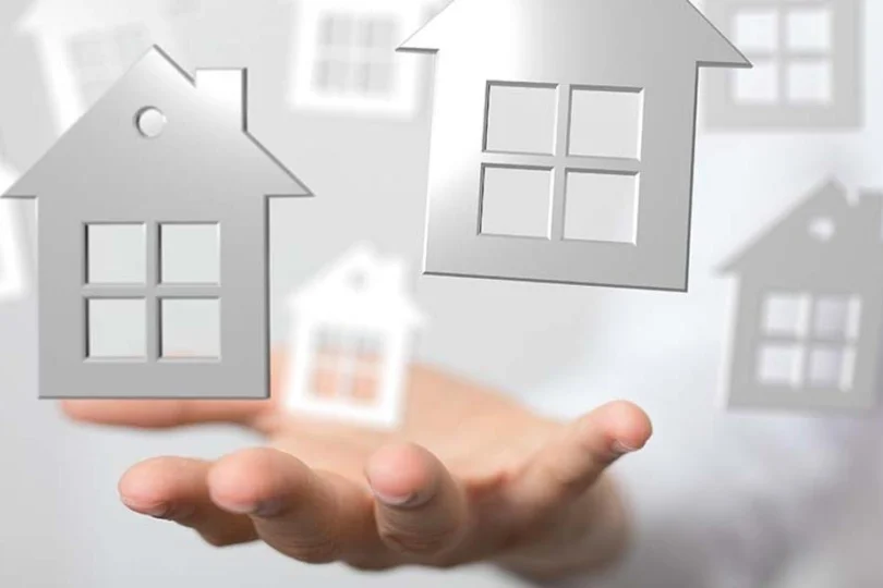 Grafika przedstawiające zarysy domów na rozpostartej dłoni.