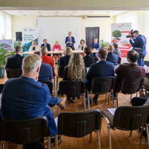 Zdjęcie przedstawia uczestników uroczystości podpisania umowy na zakup autobusów wodorowych