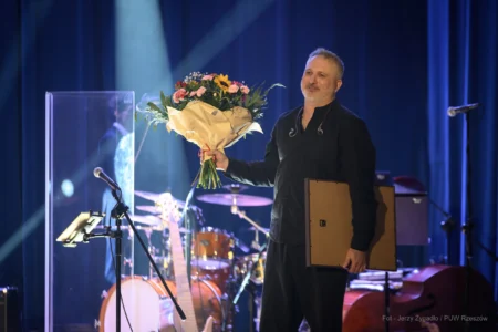 Paweł Steczkowski, uhonorowany prestiżowym Medalem Gloria Artis, z bukietem kwiatów.