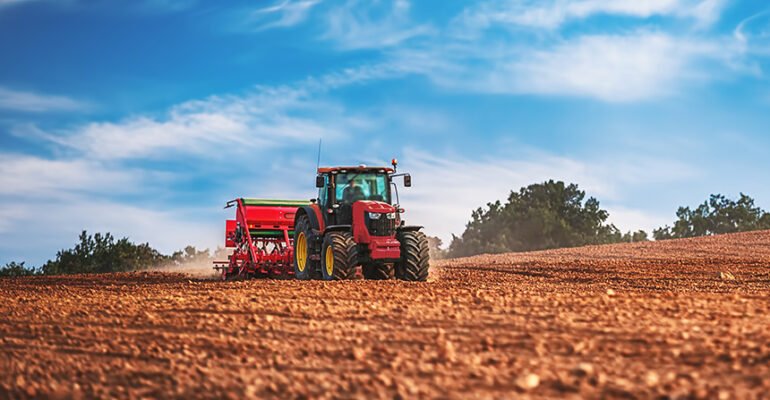 Zdjęcie przedstawia traktor na polu uprawnym