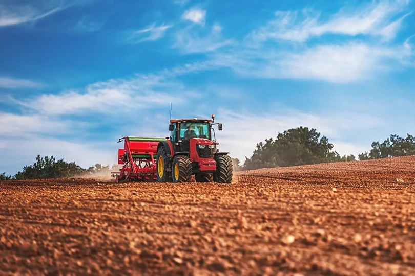 Zdjęcie przedstawia traktor na polu uprawnym