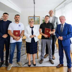 Zdjęcie przedstawia uczestników uroczystości podpisania umowy na wsparcie ratownictwa wodnego