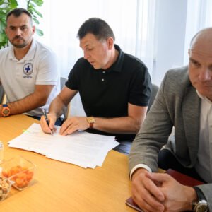 Zdjęcie przedstawia uczestników uroczystości podpisania umowy na wsparcie ratownictwa wodnego