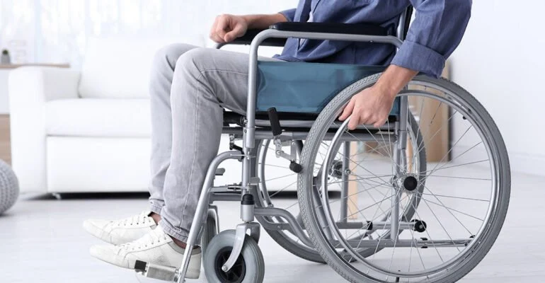 Zdjęcie przedstawia osobę na wózku inwalidzkim