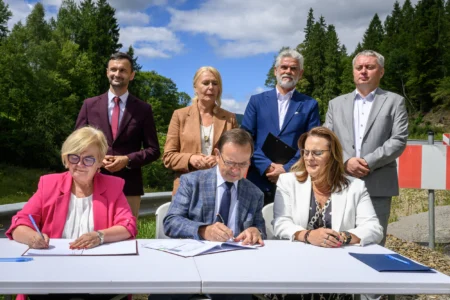 Zdjęcie przedstawia uczestników uroczystości podpisania umowy na zabezpieczenie osuwiska w Cisnej