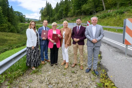 Zdjęcie przedstawia uczestników uroczystości podpisania umowy na zabezpieczenie osuwiska w Cisnej