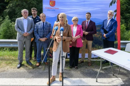 Zdjęcie przedstawia uczestników uroczystości podpisania umowy na zabezpieczenie osuwiska w Cisnej