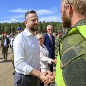 Powitanie ministra obrony narodowej z żołnierzami na poligonie.