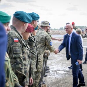Jerzy Tabin, dyrektor Biura Wojewody witający się z żołnierzami na poligonie w Nowej Dębie.