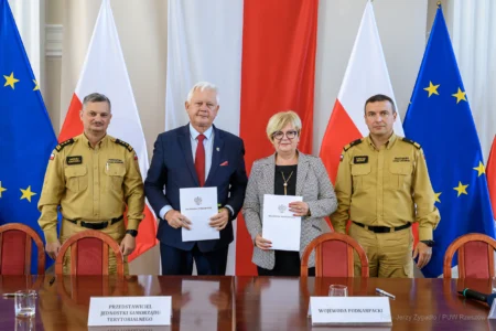 Zdjęcie przedstawia uczestników podpisania umów w ramach programu ochrony ludności i obrony cywilnej