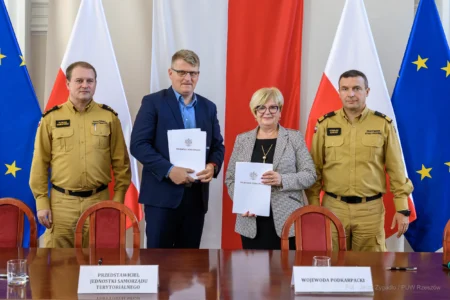 Zdjęcie przedstawia uczestników podpisania umów w ramach programu ochrony ludności i obrony cywilnej