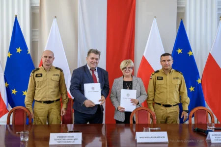 Zdjęcie przedstawia uczestników podpisania umów w ramach programu ochrony ludności i obrony cywilnej