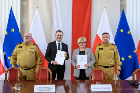 Zdjęcie przedstawia uczestników podpisania umów w ramach programu ochrony ludności i obrony cywilnej