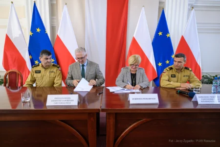 Zdjęcie przedstawia uczestników podpisania umów w ramach programu ochrony ludności i obrony cywilnej