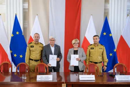 Zdjęcie przedstawia uczestników podpisania umów w ramach programu ochrony ludności i obrony cywilnej