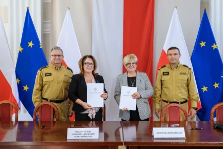 Zdjęcie przedstawia uczestników podpisania umów w ramach programu ochrony ludności i obrony cywilnej