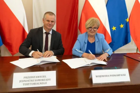 Zdjęcie przedstawia uczestników podpisania umów w sali kolumnowej urzędu wojewódzkiego