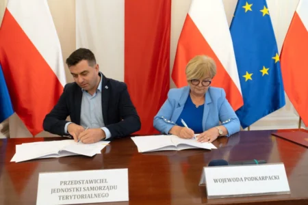 Zdjęcie przedstawia uczestników podpisania umów w sali kolumnowej urzędu wojewódzkiego