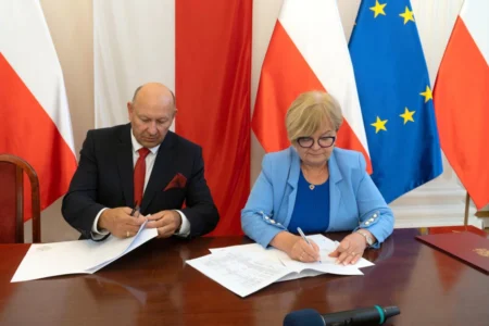 Zdjęcie przedstawia uczestników podpisania umów w sali kolumnowej urzędu wojewódzkiego