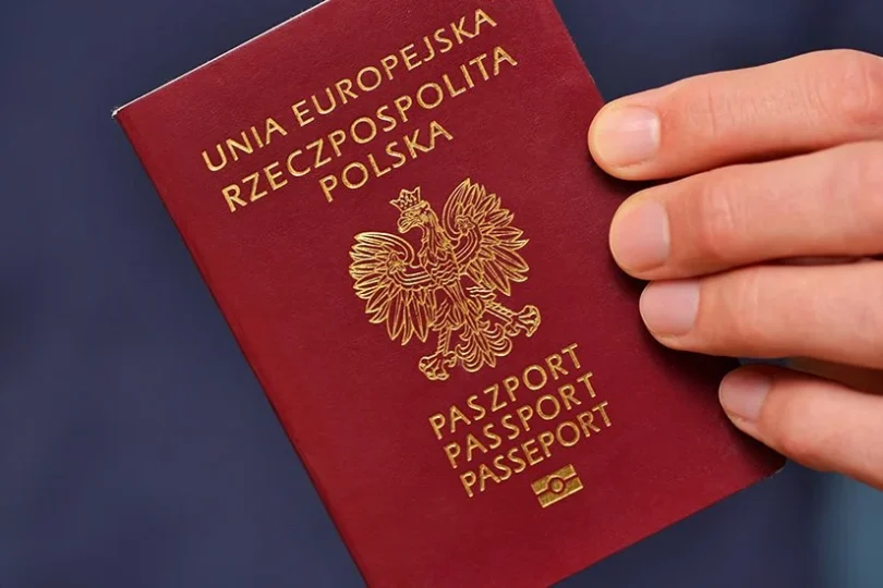 Dłoń trzymająca polski paszport.