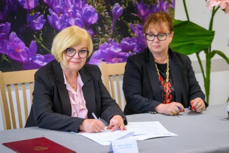 Zdjęcie przedstawia uczestników uroczystości podpisania umowy w ramach programu Centra Opiekuńczo-Mieszkalne